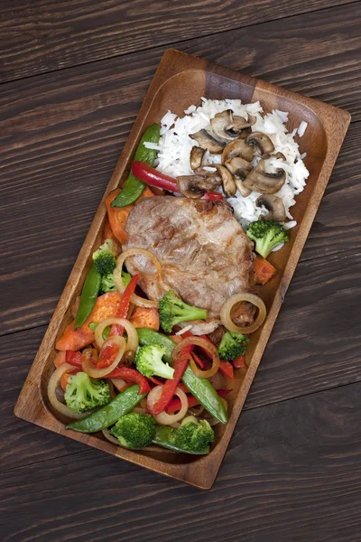 Meat with vegetables on wooden table — Stock Photo, Image