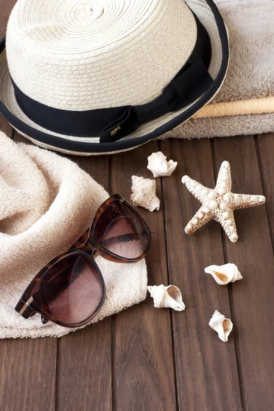 Solglasögon och korgvide hatt på bord — Stockfoto