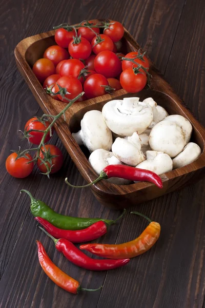 Sladké zralé rajčata a houby na dřevěný stůl — Stock fotografie