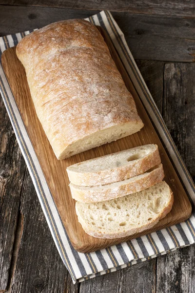 Ciabatta en rodajas sobre fondo de madera — Foto de Stock