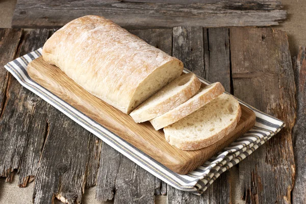 Ciabatta fatiada em fundo de madeira — Fotografia de Stock