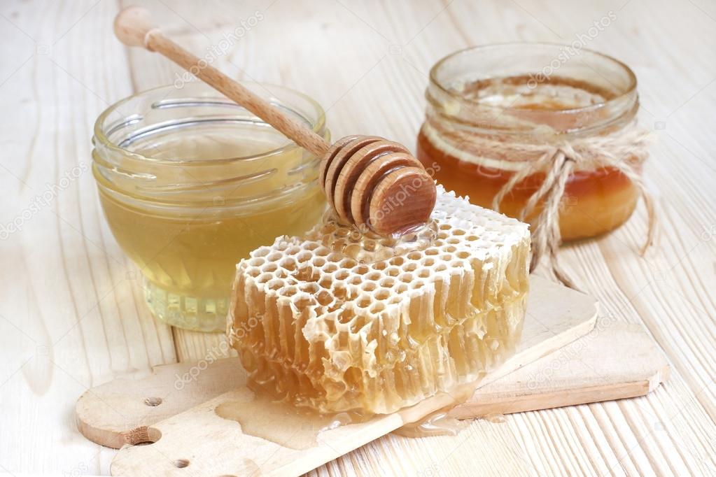 Glass cans full of honey on  wooden table