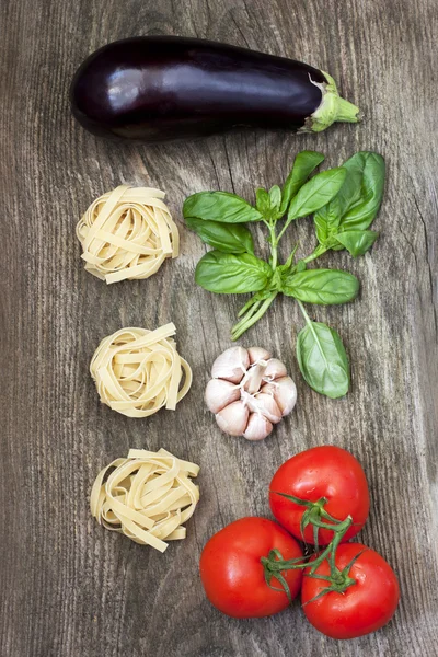 Frisches Gemüse und rohe Pasta auf Holzgrund — Stockfoto