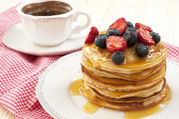 Frukost med pannkakor på keramiska plattan. Pannkakor dränkt med honung — Stockfoto
