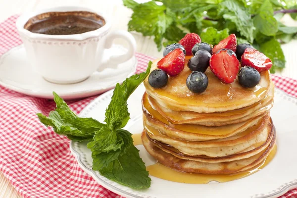 Ontbijt van pannenkoeken op keramische plaat. Pannenkoeken doorweekt met honing — Stockfoto