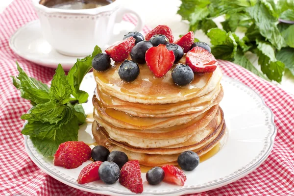 Frukost med pannkakor på keramiska plattan. Pannkakor dränkt med honung — Stockfoto