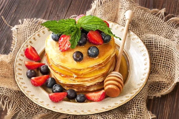 セラミック プレートにパンケーキの朝食。蜂蜜と降り注ぐパンケーキ — ストック写真