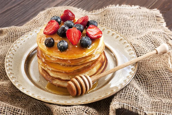 Frühstück mit Pfannkuchen auf Keramikteller. Pfannkuchen mit Honig getränkt — Stockfoto