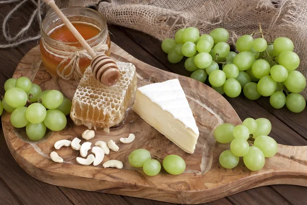 Camembert de queso con miel y frutos secos servidos con uva —  Fotos de Stock