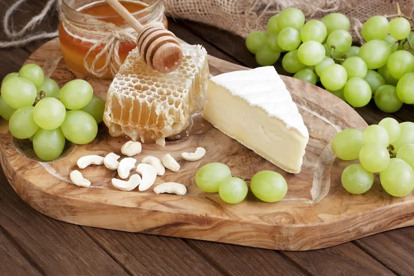 Cheese camembert with honey and nuts served with grape — Zdjęcie stockowe
