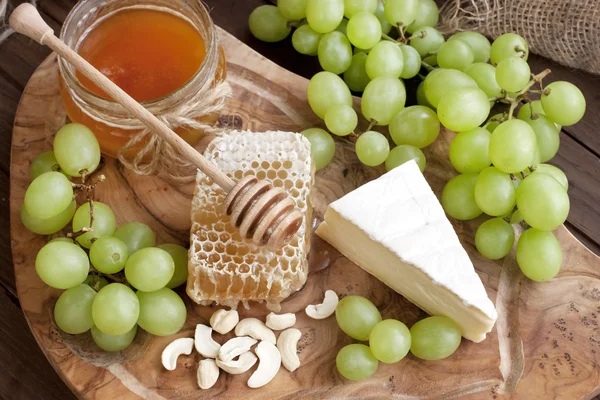 Camembert de queijo com mel e nozes servidos com uva — Fotografia de Stock