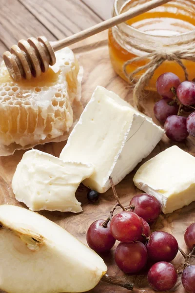 Натюрморт с сыром, виноградом и медом — стоковое фото