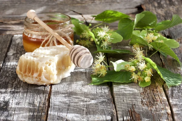Latas de vidro cheias de mel na mesa de madeira — Fotografia de Stock