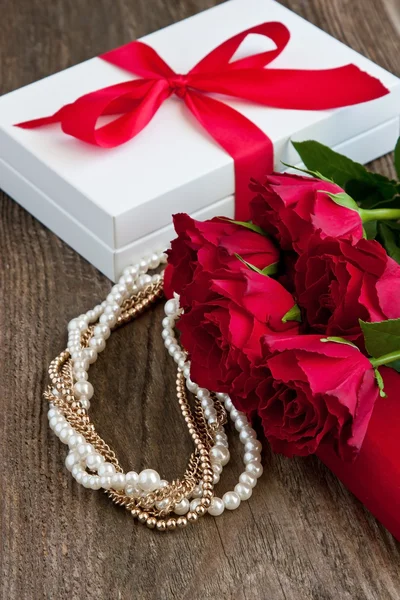 Red roses and gift box on  wooden background — Stock Photo, Image