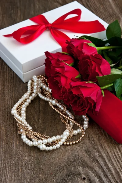 Rose rosse e scatola regalo su sfondo di legno — Foto Stock