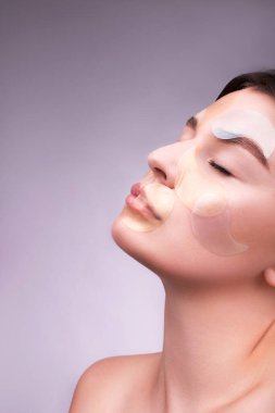 Yamalı güzel bir beyaz kız. Göz bantları. Cilt bakımı kavramı. Göz altı yamaları. Metin için alanı kopyala.