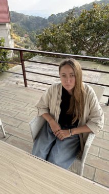 Ciddi İfadesi Olan Genç Kadın Balkonda Oturuyor