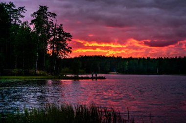 Rusya 'da gölün üzerinde bulutlarla kırmızı gün batımı