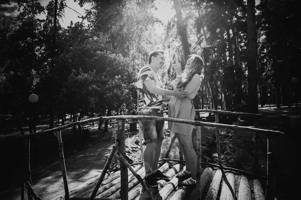 Preto branco fotografia romântico jovem casal beijando e ficar para ponte no fundo — Fotografia de Stock