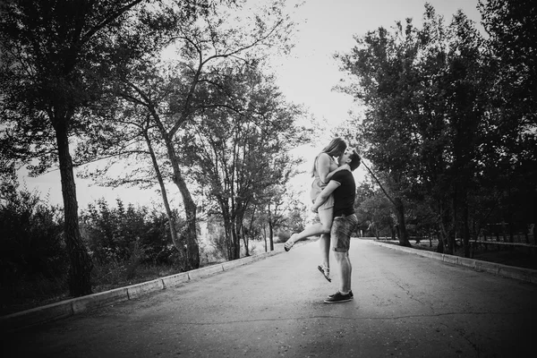 Černá bílá fotografie romantický mladý pár líbání na pozadí letní lesní — Stock fotografie