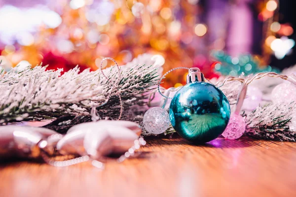 Spruce branches in the snow, and blue balls wooden background — Stock Photo, Image