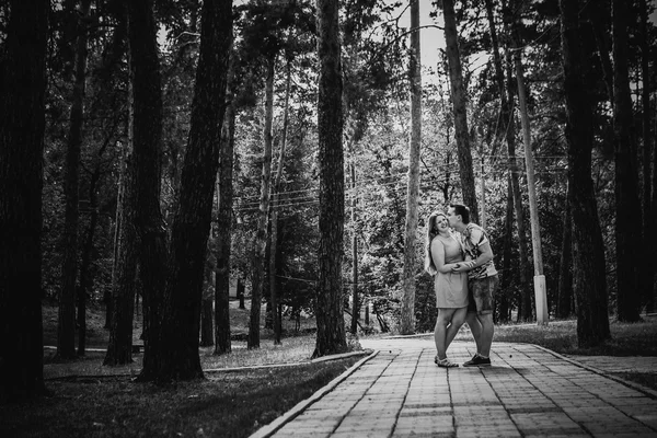 Zwart-wit fotografie romantische jonge paar zoenen op achtergrond zomer bos — Stockfoto