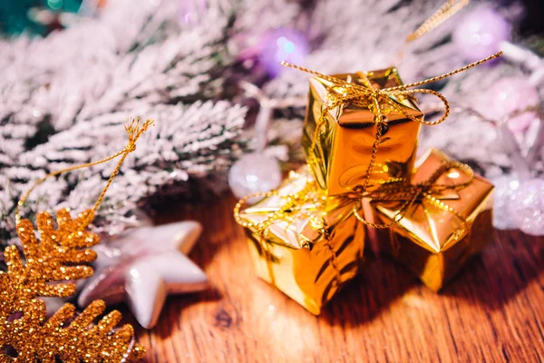 Spruce branches in the snow gold and white christmas decoration on wooden background — Stock Photo, Image