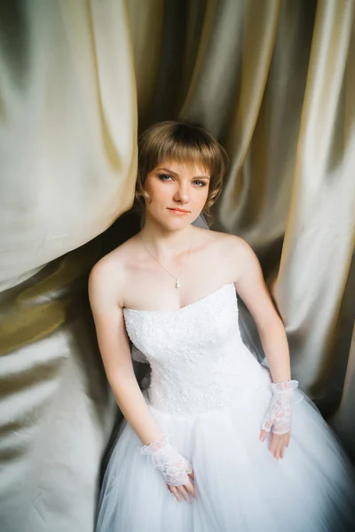 Retrato uma bela noiva jovem no fundo de tecidos — Fotografia de Stock