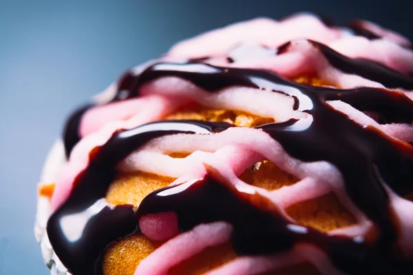 Cupcake mit rosa Zuckerguss auf einem hölzernen Hintergrund in Nahaufnahme — Stockfoto