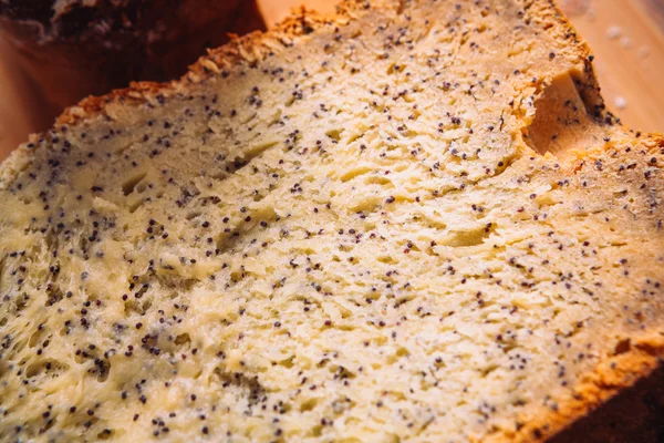 Chiudi fetta di pane fresco con semi di papavero su fondo di legno — Foto Stock