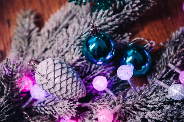 Branches d'épinette dans la neige boules de Noël bleu violet et blanc sur fond de bois foncé — Photo