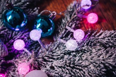 Koyu ahşap arka plan üzerinde kar menekşe mavi ve beyaz Noel topları Ladin şubeleri