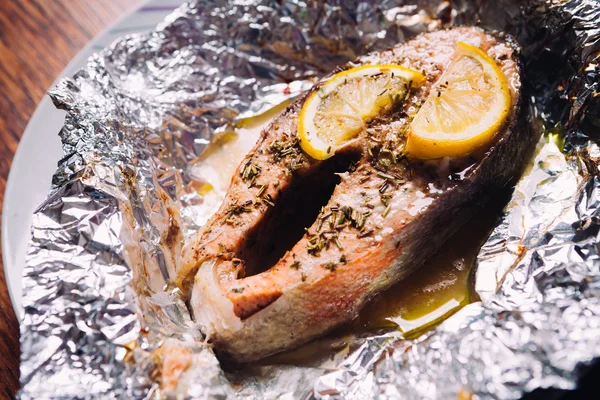 Fish steak baked with lemon and herbs in foil — Stock Photo, Image