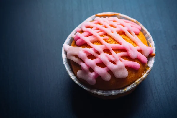 Cupcake with pink frosting on a wooden background — Stock Photo, Image