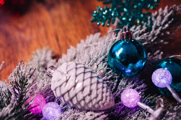 Spruce branches in the snow violet blue and white christmas balls on dark wooden background — Stock Photo, Image