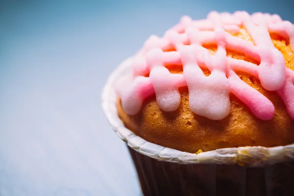 Cupcake vaaleanpunainen kuorrutus puinen tausta — kuvapankkivalokuva