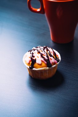 cupcake pembe krema ve ahşap arka plan üzerinde kırmızı Kupası