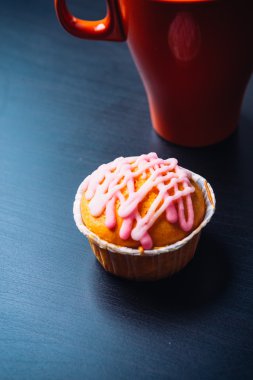 cupcake pembe krema ve ahşap arka plan üzerinde kırmızı Kupası