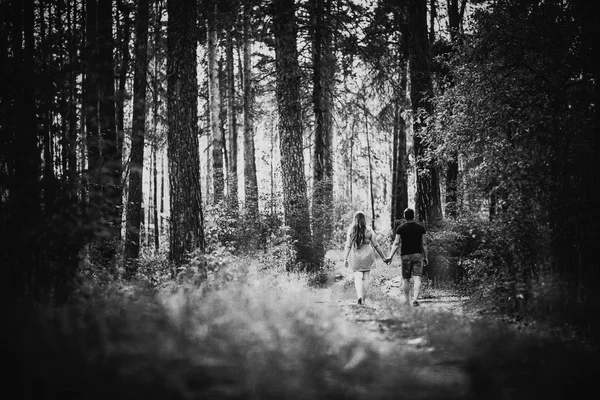 Zwart wit fotografie romantische jonge koppel ga en holding hands op achtergrond zomer — Stockfoto