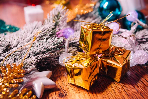 Ramas de abeto en la nieve oro y decoración de navidad blanca sobre fondo de madera —  Fotos de Stock