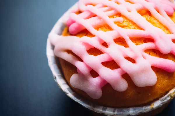 Cupcake com cobertura rosa em um fundo de madeira — Fotografia de Stock