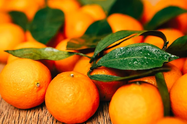 Viele frische Mandarinen auf einem hölzernen Hintergrund — Stockfoto