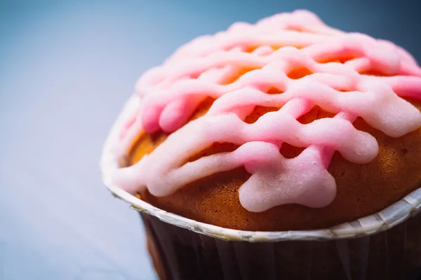 Pembe ahşap bir arka plan üzerinde buzlanma ile cupcake — Stok fotoğraf