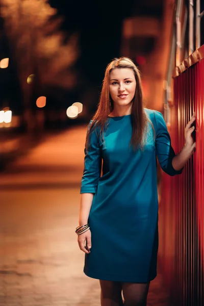 Beautiful girl in a blue dress against the backdrop of the city at night — Stock Photo, Image