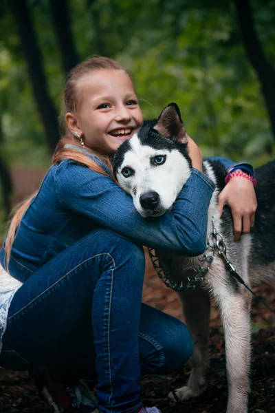 娘と春の葉の背景にハスキー犬 — ストック写真