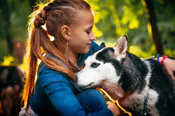 娘と春の葉の背景にハスキー犬 — ストック写真