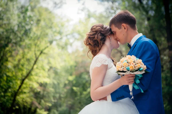 Young bride and groom embracing against the backdrop of the forest the road — Stock Photo, Image