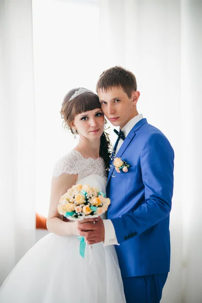 Наречений і наречений в студії світла стоять на білому тлі — стокове фото