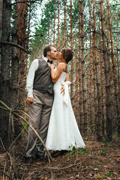 Dramática imagen novia y novio en el fondo de las hojas bosque luz de fondo — Foto de Stock