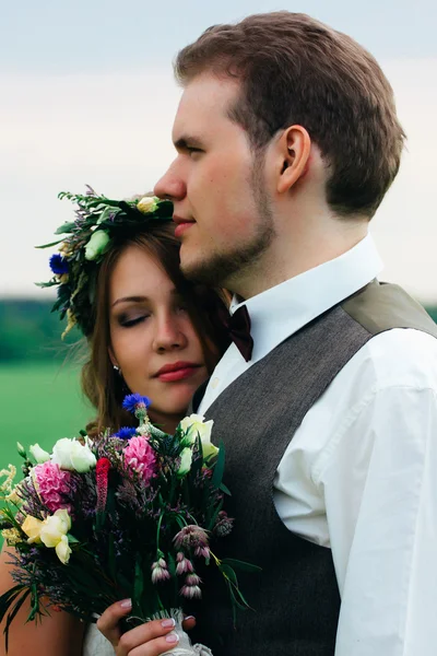 Portrét nevěsty a ženicha s kyticí na zelené louce — Stock fotografie